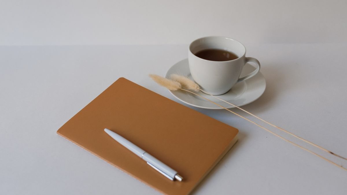 ノートとペン、飲み物を用意した落ち着いた机