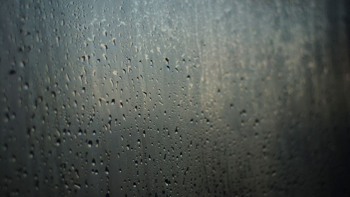 雨粒がついた窓の向こうのぼやけた景色